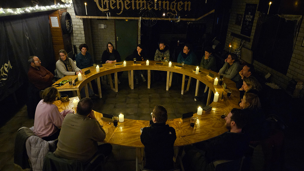 De ronde beraadtafel vol kaarsen in het paviljoen van De Geheimelingen